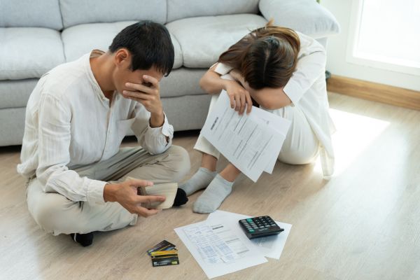 não organizar finanças pessoais erro financeiro Casal preocupado analisando contas e cartões de crédito representando erro financeiro de não organizar as finanças pessoais
