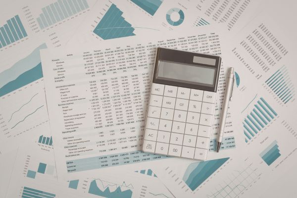 o que é independência financeira Documentos financeiros com gráficos e calculadora representando o conceito de independência financeira