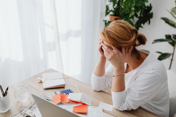por que a maioria das pessoa não conseguem sair das dívidas mulher preocupada mulher preocupada com contas e dívidas analisando despesas em casa
