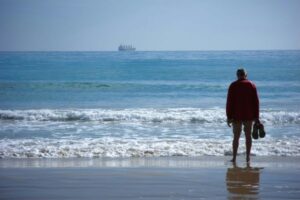 pessoa olhando o horizonte do mar refletindo sobre recomeçar a vida após momento difícil