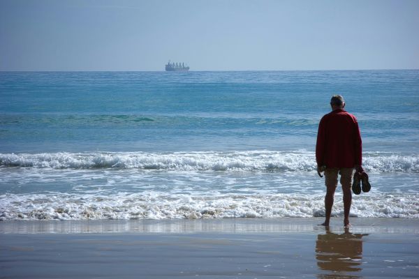 pessoa olhando o horizonte do mar refletindo sobre recomeçar a vida após momento difícil