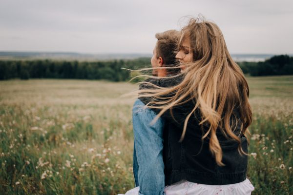 relacionamento amor conexão casal natureza Casal abraçado em campo aberto representando amor, conexão e relacionamento saudável