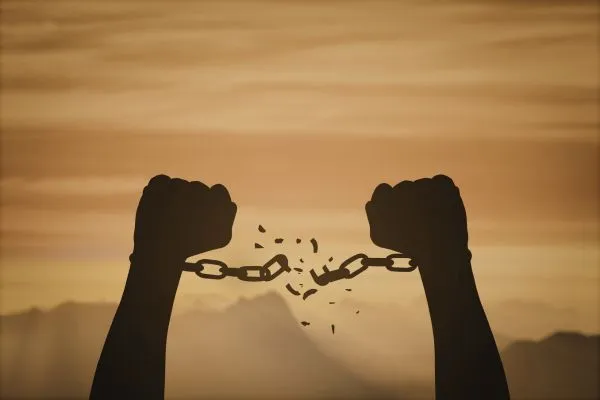 mãos quebrando correntes simbolizando superação do medo e libertação emocional