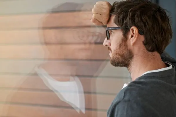 como-vencer-o-medo-reflexao-interna homem olhando seu reflexo com expressão pensativa representando medo interno e conflito emocional
